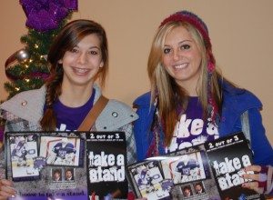 Isabel and Rosamond Thalken pose with the posters YAB created when they partnered with the Storm Hockey Team in 2009.